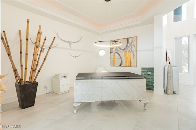 miscellaneous room featuring ornamental molding, a raised ceiling, and baseboards