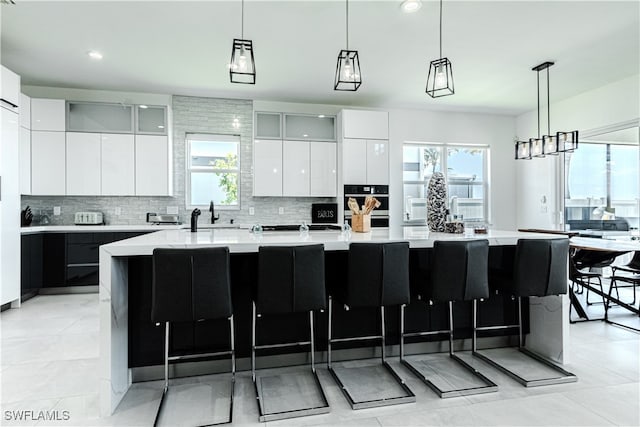 kitchen featuring light countertops, double oven, modern cabinets, and white cabinetry