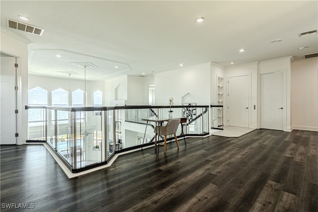 corridor with visible vents, crown molding, and wood finished floors