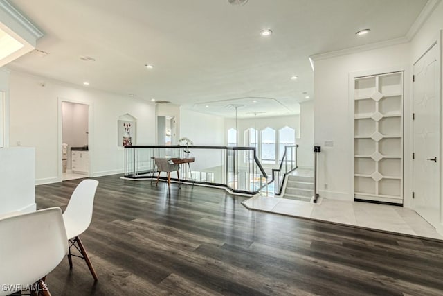 exercise room featuring baseboards, ornamental molding, wood finished floors, built in shelves, and recessed lighting