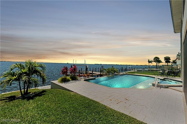 view of swimming pool featuring a water view, a patio area, a pool with connected hot tub, and a lawn