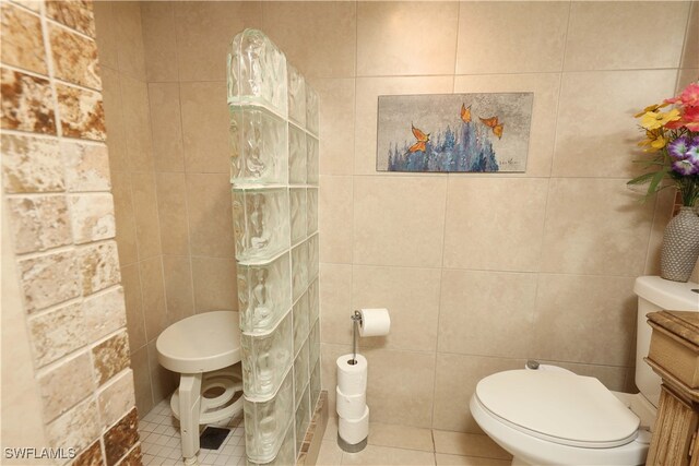 bathroom with tile patterned flooring, tile walls, and toilet