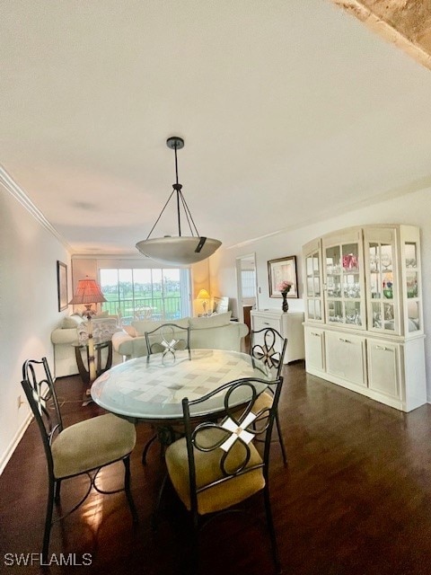 dining area featuring ornamental molding and dark hardwood / wood-style floors