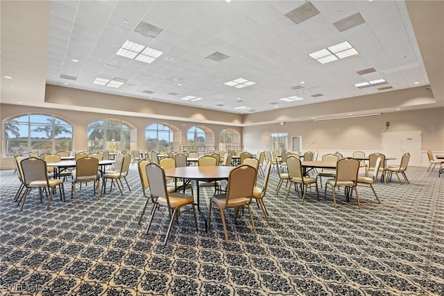 dining space featuring a high ceiling and carpet floors