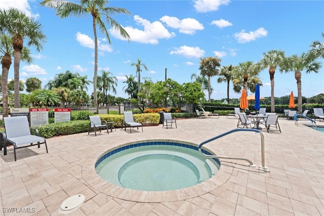 view of swimming pool with a hot tub and a patio area