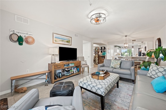 living room featuring a chandelier and light tile patterned flooring