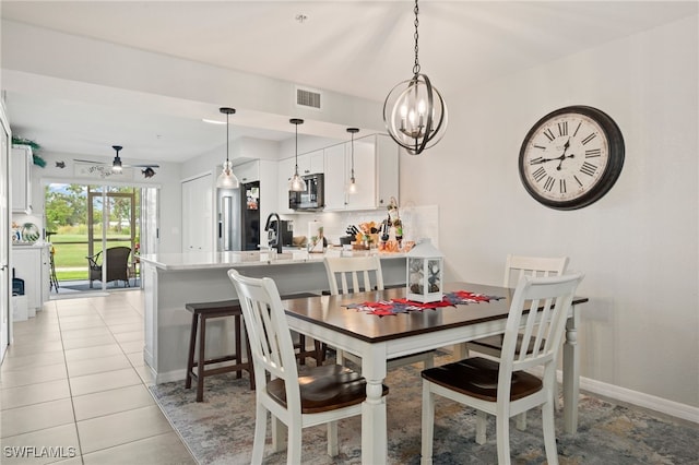 dining room featuring light tile patterned floors and ceiling fan with notable chandelier