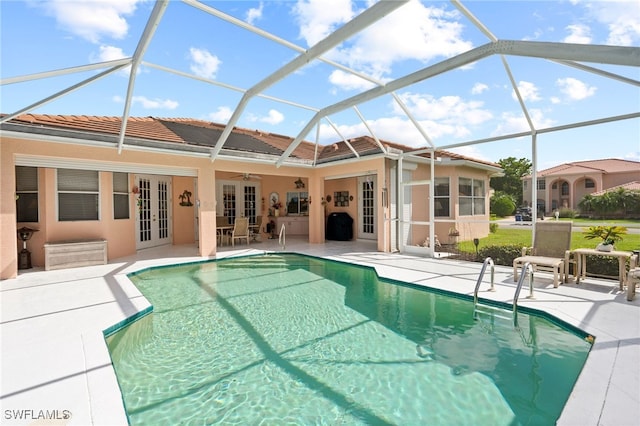 view of swimming pool with a lanai, french doors, and a patio