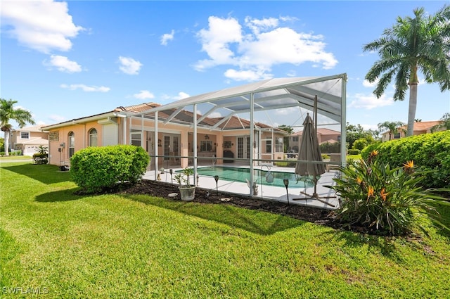 view of swimming pool featuring a yard and glass enclosure