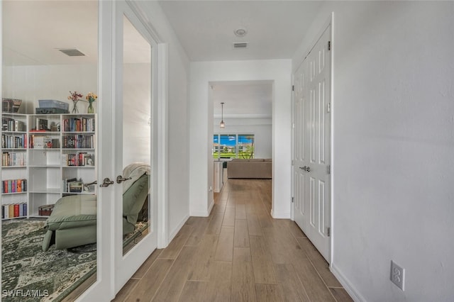 hallway with light hardwood / wood-style floors