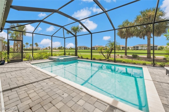 view of pool featuring a yard, glass enclosure, an in ground hot tub, and a patio area