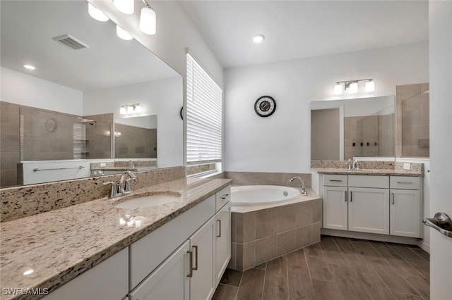 bathroom with shower with separate bathtub, wood-type flooring, and vanity