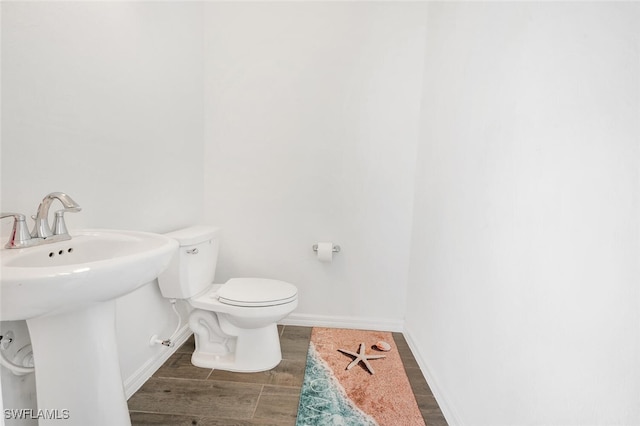 bathroom featuring wood-type flooring, sink, and toilet