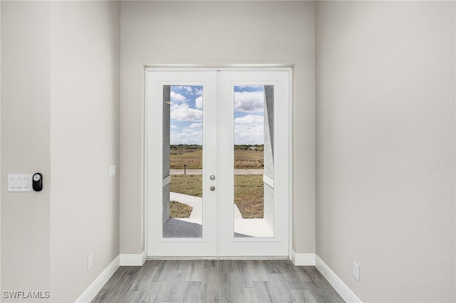 doorway with french doors and light hardwood / wood-style floors