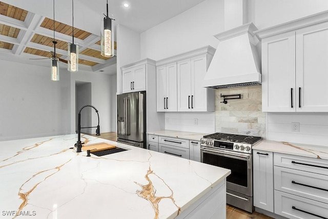 kitchen with appliances with stainless steel finishes, premium range hood, light stone counters, and sink