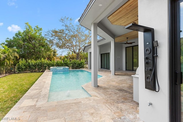 view of pool featuring a lawn, ceiling fan, a patio, and an in ground hot tub