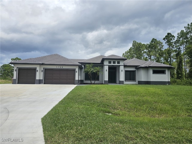 prairie-style house featuring a front lawn and a garage