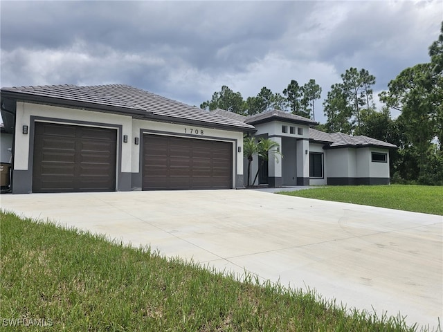 prairie-style house with a garage and a front lawn