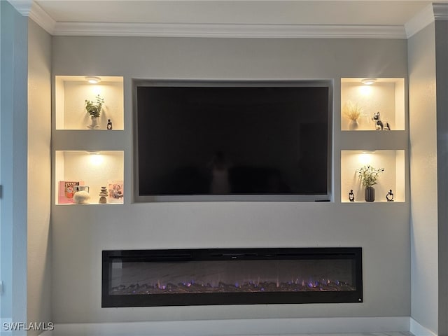 interior details with built in features, a glass covered fireplace, and crown molding