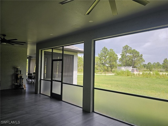 unfurnished sunroom with a ceiling fan