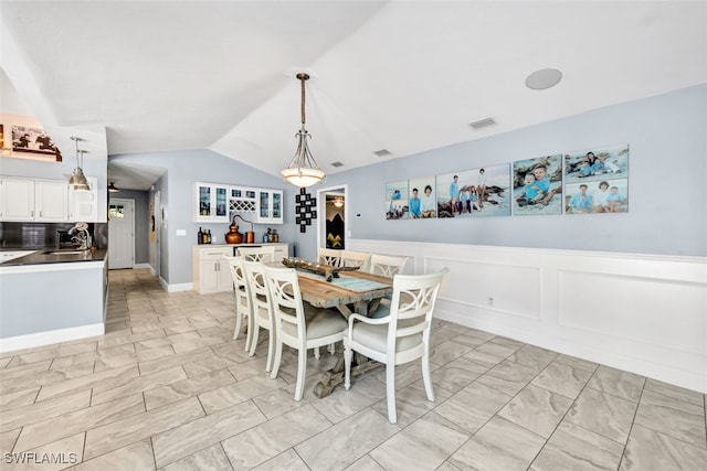 dining room featuring sink and vaulted ceiling