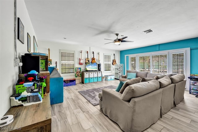 living room featuring ceiling fan and light hardwood / wood-style floors