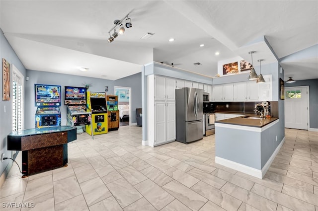 kitchen featuring stainless steel appliances, kitchen peninsula, sink, ceiling fan, and white cabinets