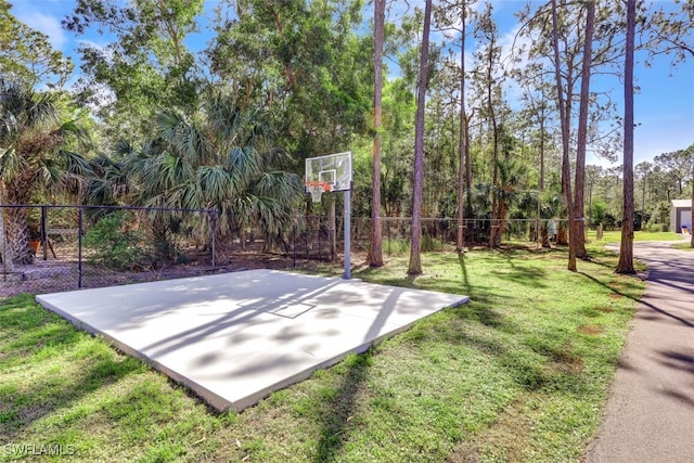 view of sport court with a lawn