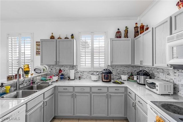 kitchen featuring dishwasher, plenty of natural light, tasteful backsplash, and sink