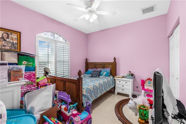 bedroom with light tile patterned floors, ceiling fan, and a closet