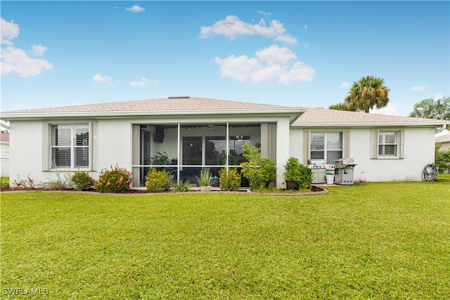 rear view of property with a sunroom and a yard