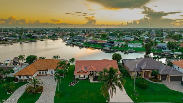 aerial view at dusk featuring a water view