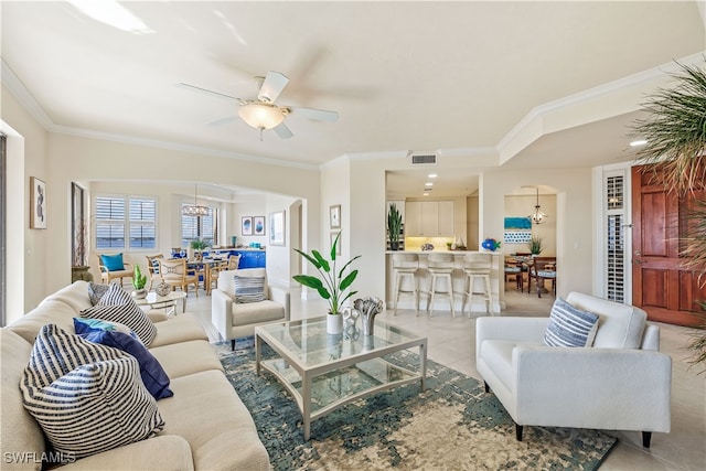 tiled living room with ornamental molding and ceiling fan with notable chandelier