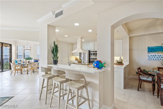 kitchen with extractor fan, crown molding, a notable chandelier, light tile patterned floors, and white cabinetry