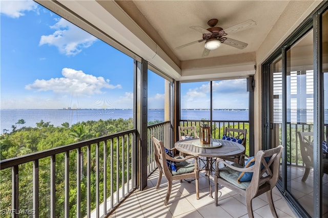 sunroom featuring a water view and ceiling fan