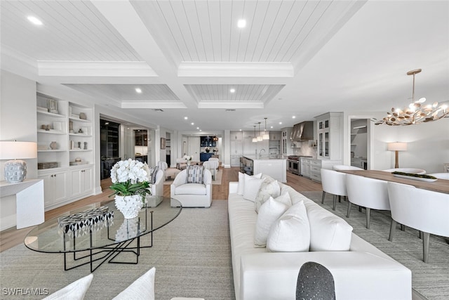 living area with a chandelier, recessed lighting, beam ceiling, and light wood finished floors