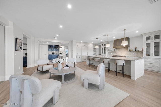 living room featuring sink and light hardwood / wood-style flooring