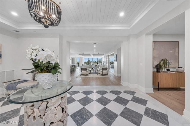 foyer entrance featuring baseboards, visible vents, wooden ceiling, an inviting chandelier, and a tray ceiling