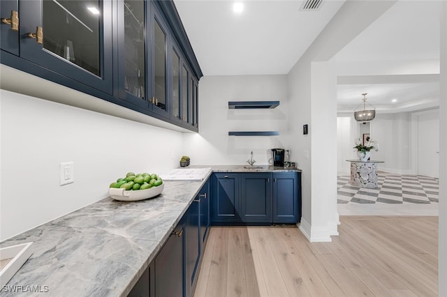 bar featuring recessed lighting, a sink, visible vents, baseboards, and light wood finished floors