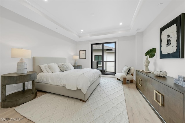 bedroom with recessed lighting, baseboards, access to exterior, a tray ceiling, and light wood finished floors