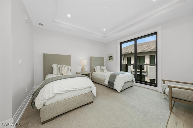 bedroom with access to exterior, a tray ceiling, crown molding, wood finished floors, and baseboards