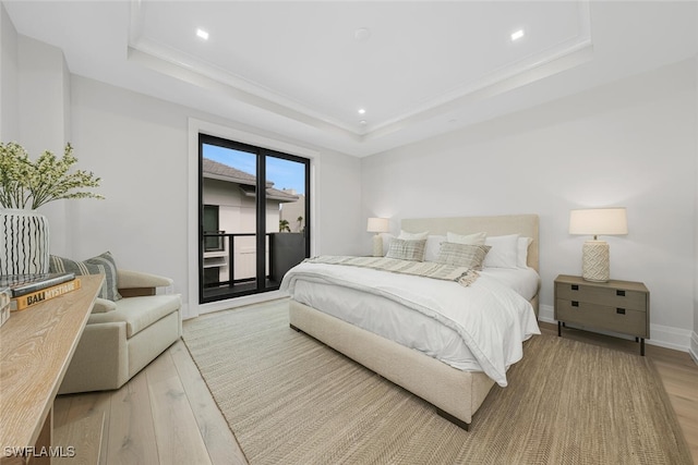 bedroom featuring recessed lighting, baseboards, access to outside, light wood-type flooring, and a tray ceiling