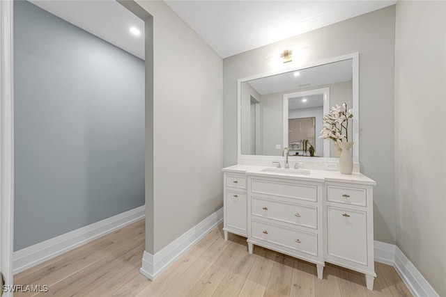 bathroom featuring wood finished floors, vanity, and baseboards