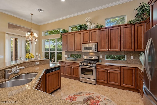 kitchen featuring visible vents, a sink, appliances with stainless steel finishes, crown molding, and tasteful backsplash