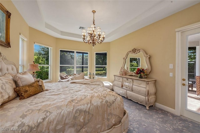 carpeted bedroom with baseboards, a raised ceiling, a notable chandelier, and visible vents