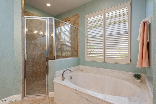 bathroom with tile patterned flooring, vaulted ceiling, a bath, and a stall shower