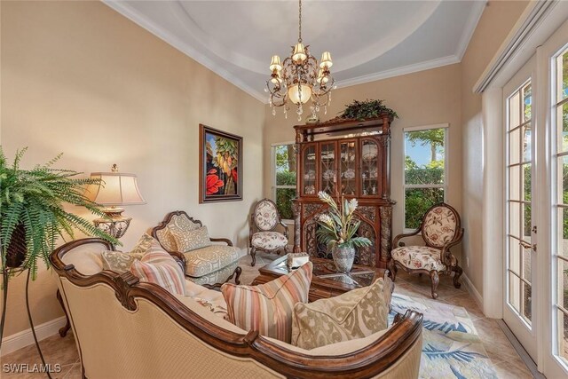 living area featuring ornamental molding, a tray ceiling, an inviting chandelier, and tile patterned flooring