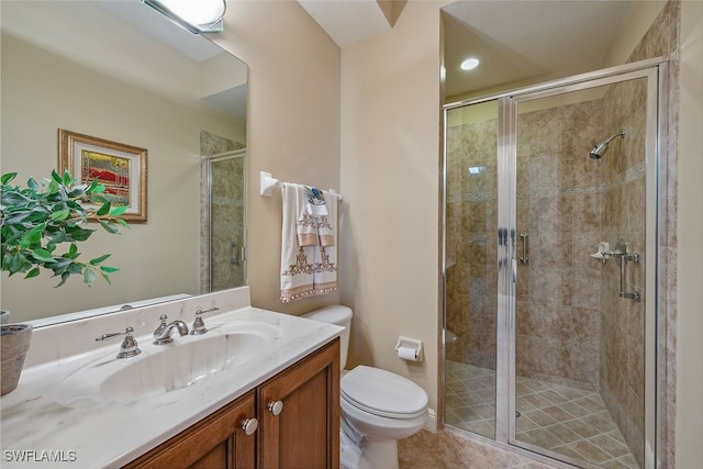 bathroom featuring a shower with door, vanity, toilet, and tile patterned floors