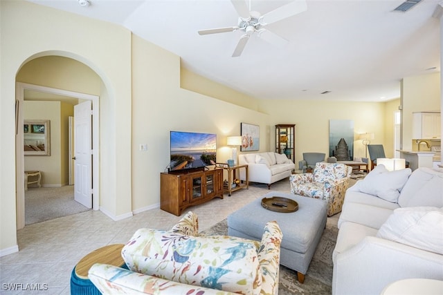 tiled living room featuring ceiling fan and sink