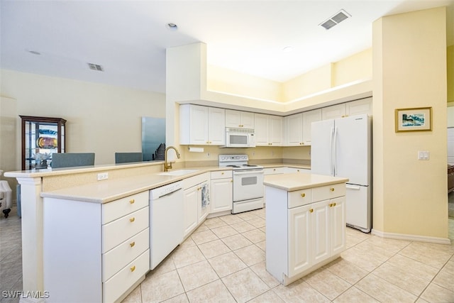 kitchen featuring sink, light tile patterned floors, kitchen peninsula, white appliances, and white cabinets